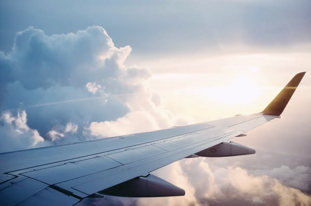 Aircraft wing above cloud cover representing aviation infrastructure