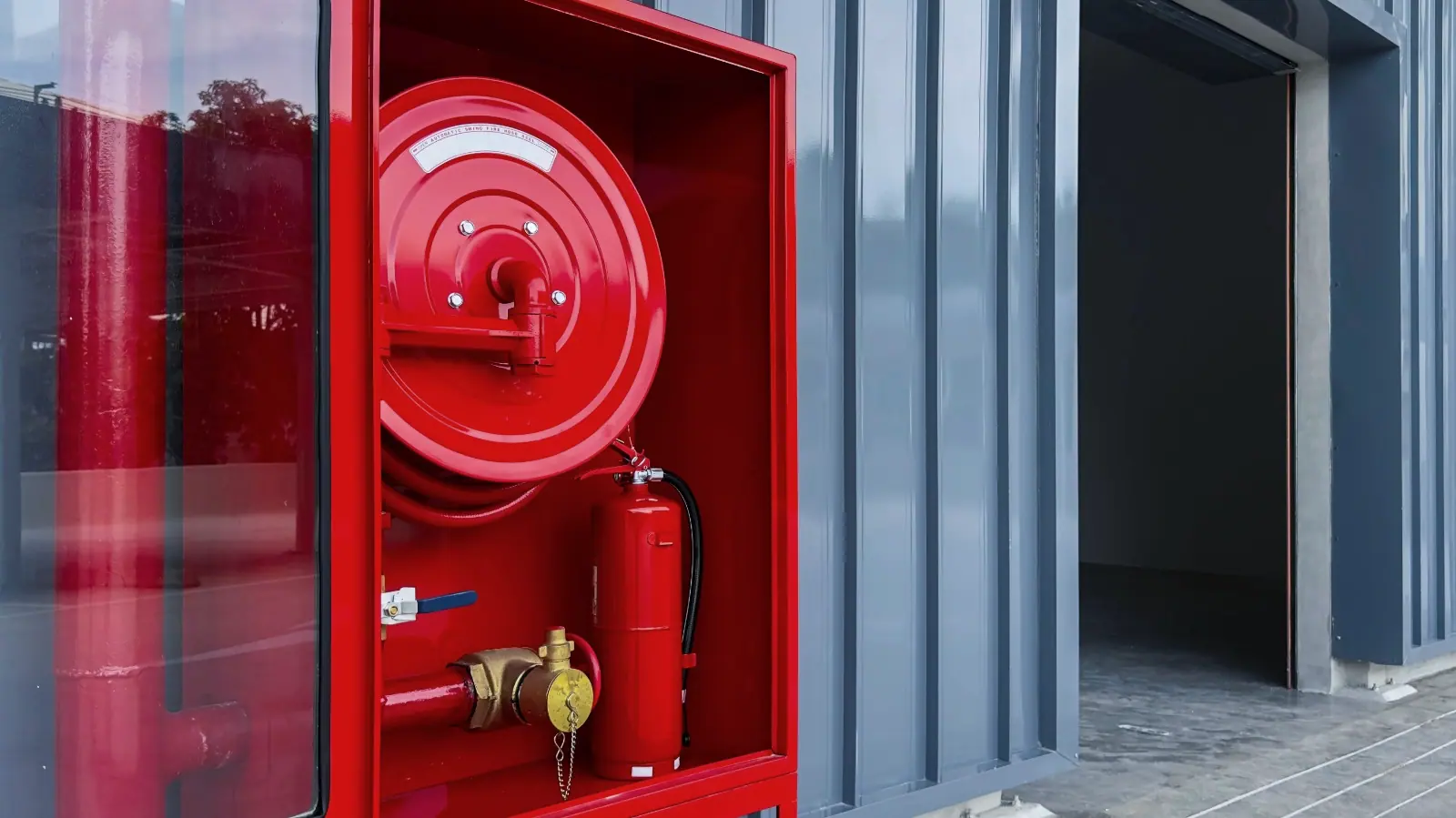 Fire hose reel and extinguisher cabinet at a facility entrance