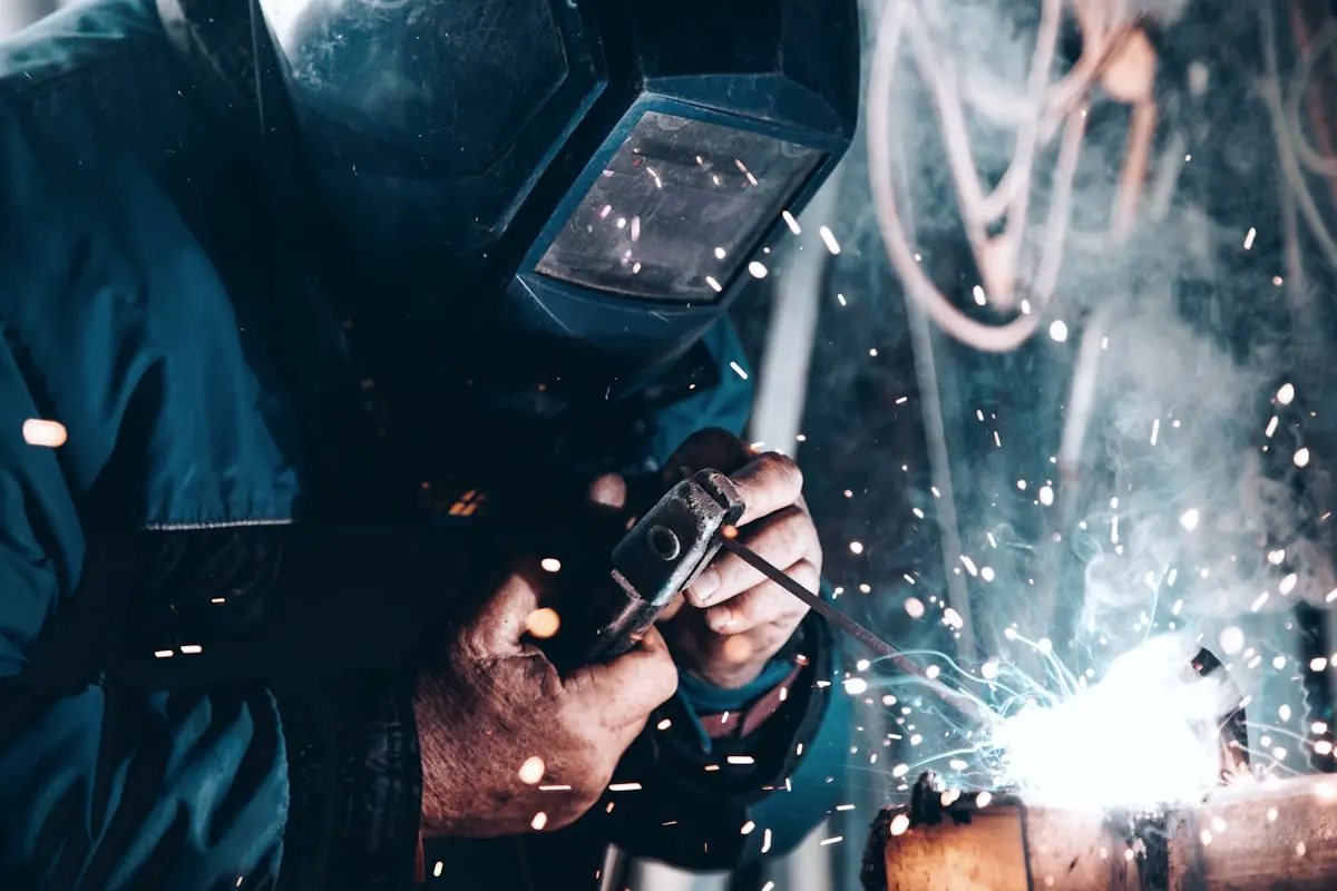 Technician working on mechanical fabrication with protective welding equipment